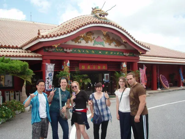 Students in front of a traditional Okinawan building